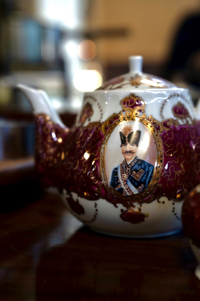 Intricately decorated china teapot with foreign dignitary painted on the side.