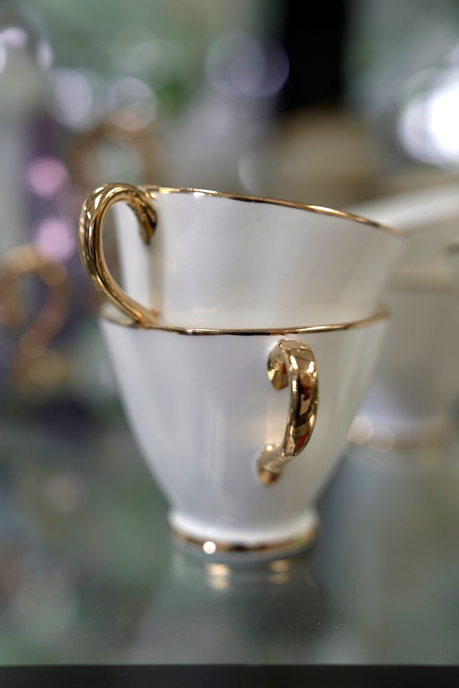 Set of white and gold tea cups stacked on top of each other at Consignment Classics Decor Store.